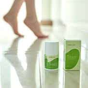 AmityCare CBD гель для ніг і м'язів — lifestyle фото з ногами жінки та флаконом гелю на підлозі