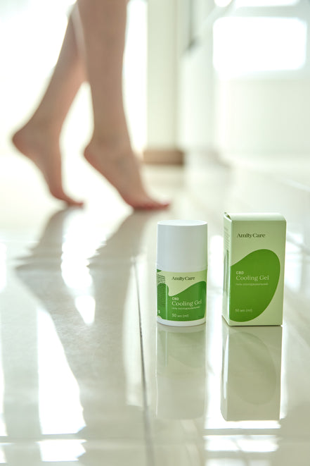 AmityCare CBD гель для ніг і м'язів — lifestyle фото з ногами жінки та флаконом гелю на підлозі